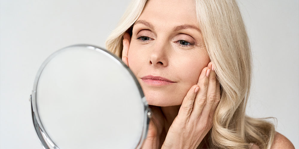 woman looking in the mirror after her early intervention facelift in Atlanta