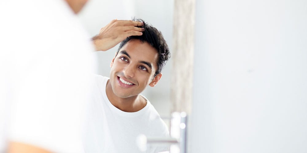 man looking in the mirror after his fue hair transplant in Atlanta, GA